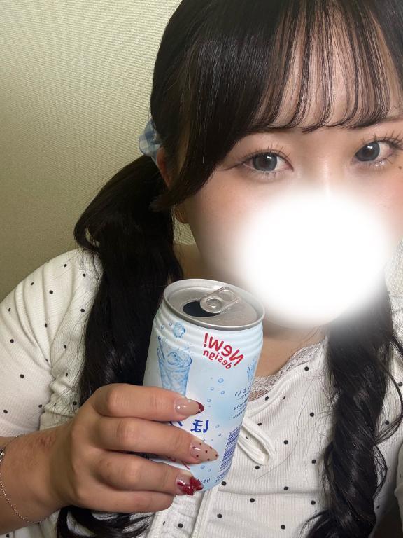 口元を白いぼかしで隠し、黒髪のツインテール姿で白い缶飲料を持つ女性